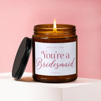 Amber candle with lit wick and "You're a Bridesmaid" text.