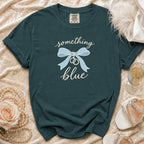 Teal t-shirt with "something blue" text, a bow, and rings.