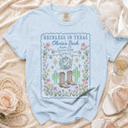 Light blue t-shirt graphic with "Reckless in Texas Olivia's Bach Austin, TX Summer 2026" text.
