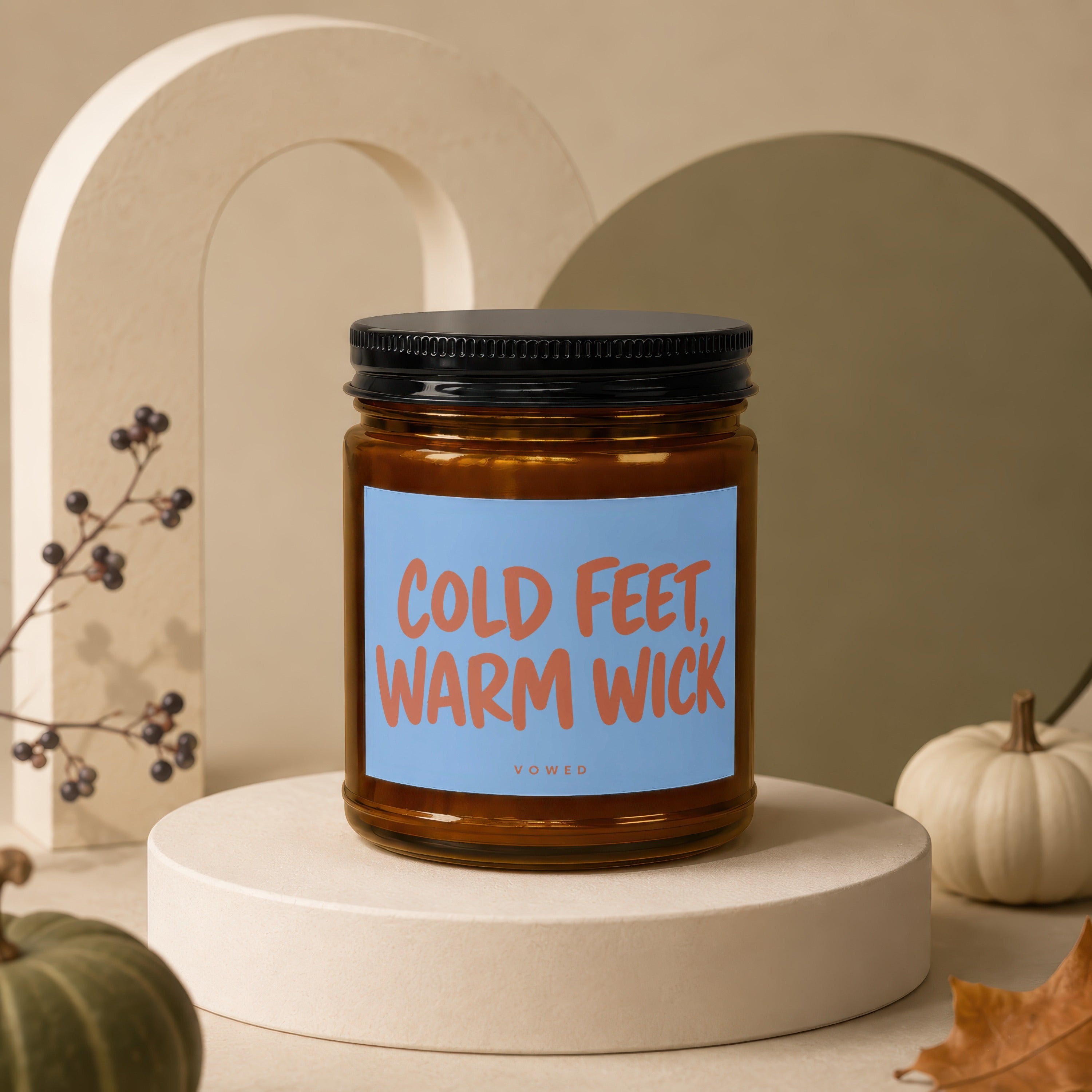Amber jar candle with "Cold Feet, Warm Wick" text on a blue label.