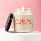 Glass jar candle with lit wick, peach label reads "So Glad You Found Each Other".