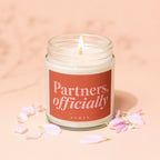 Candle with lit wick, label reads "Partners, officially VOWED".