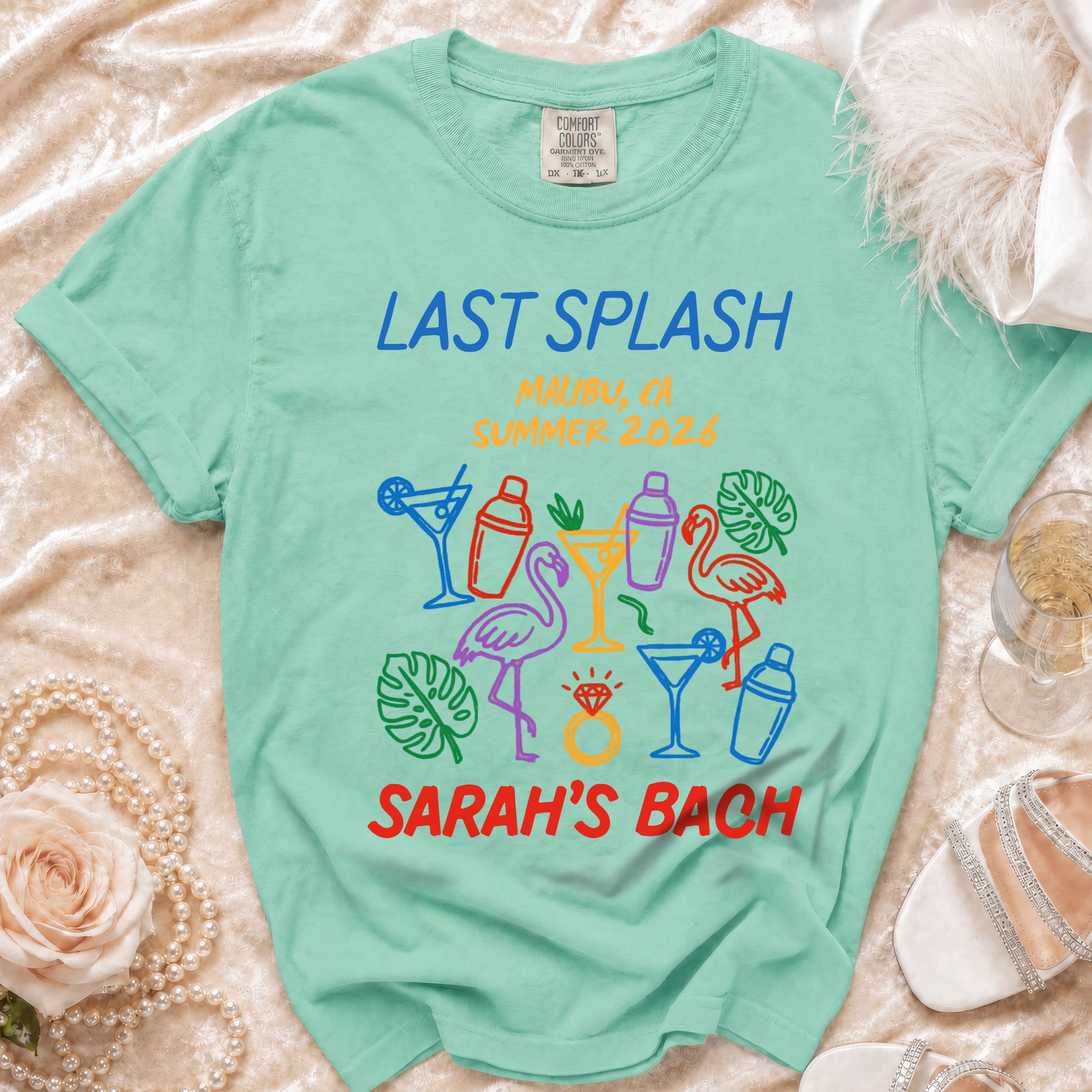 Teal t-shirt with "Last Splash Malibu 2026 Sarah's Bach" and colorful graphics.