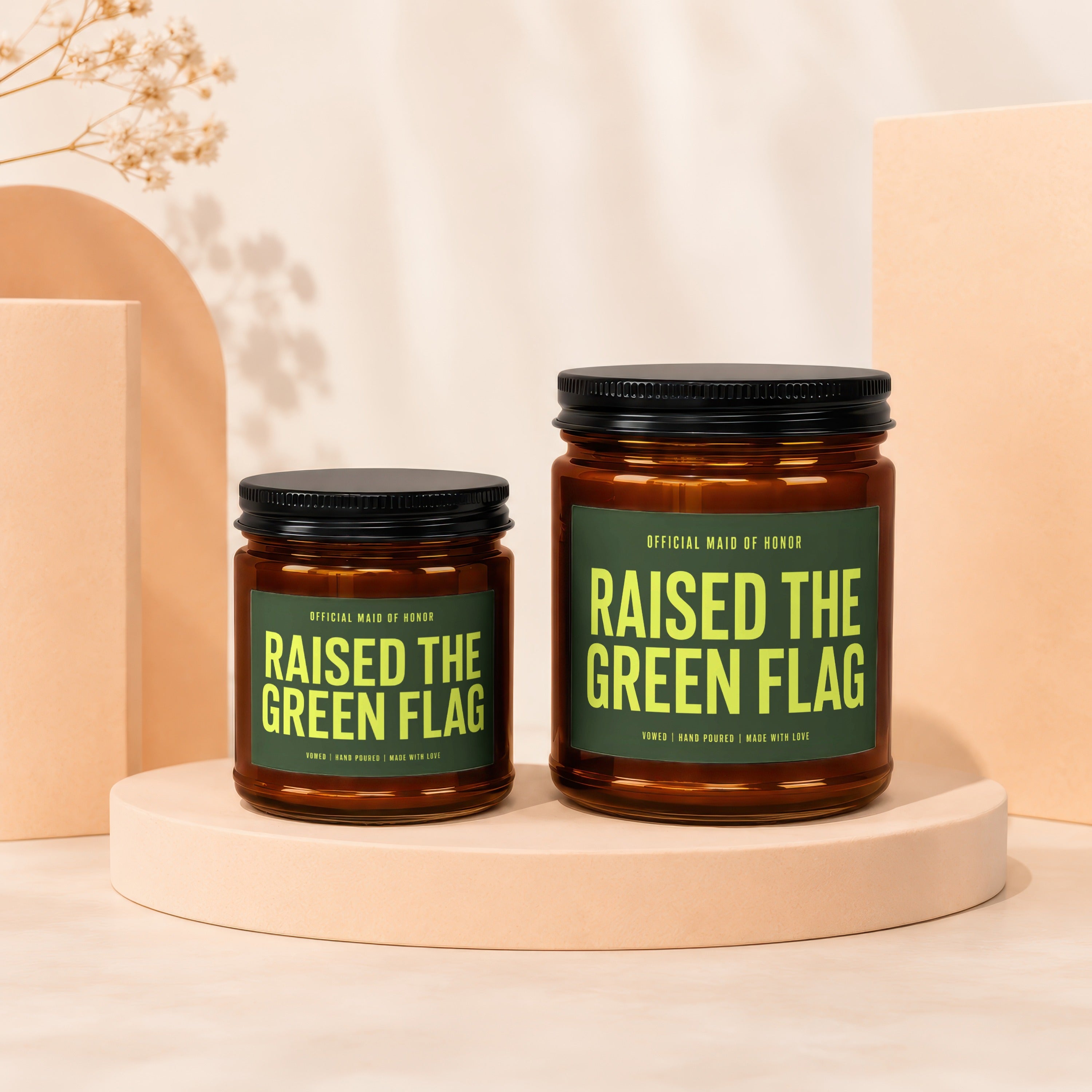 Two amber glass candles with green labels reading "RAISED THE GREEN FLAG".