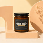 Amber jar candle with "Bride Mode Fully Activated" label, on a pedestal.
