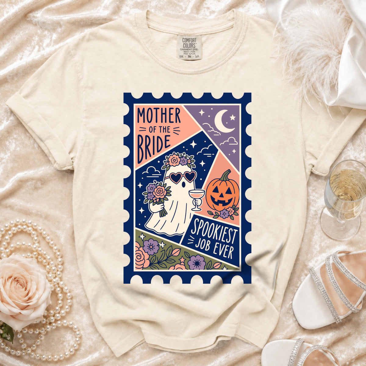 Cream t-shirt with a graphic of a ghost holding flowers and a drink, text reads "Mother of the Bride Spookiest Job Ever."