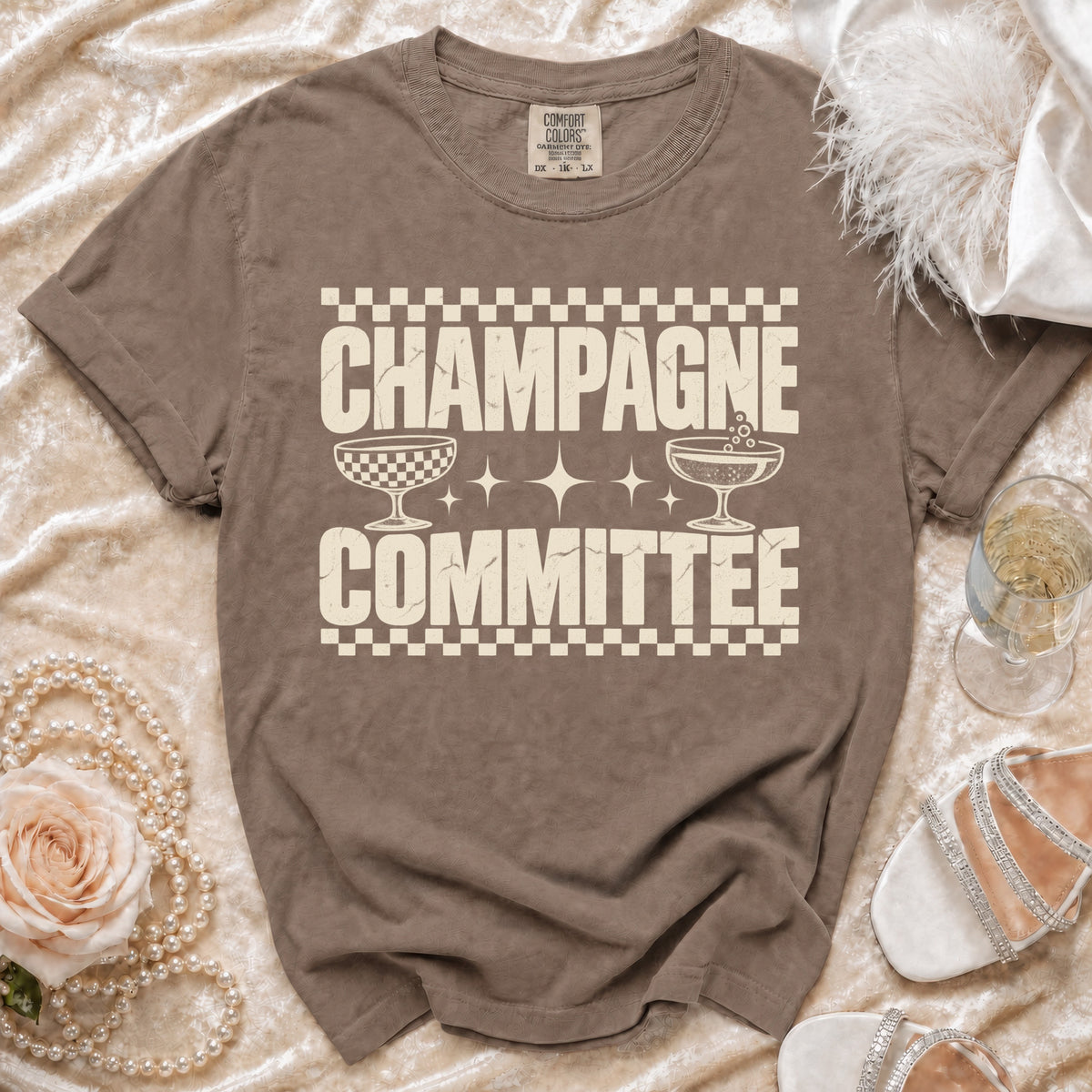 Brown t-shirt with "CHAMPAGNE COMMITTEE" text and champagne glasses graphic.