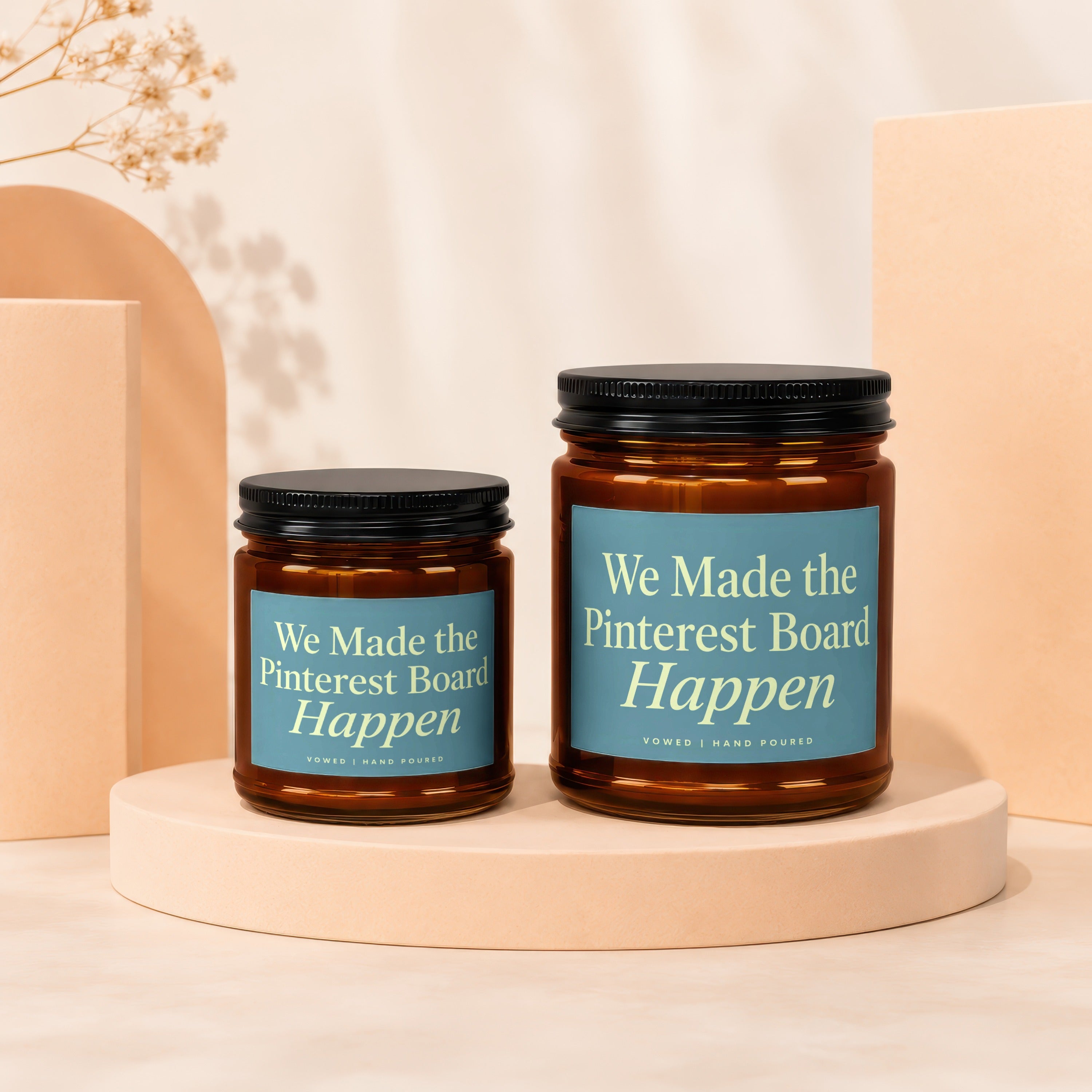 Two amber glass candles with blue labels read "We Made the Pinterest Board Happen".