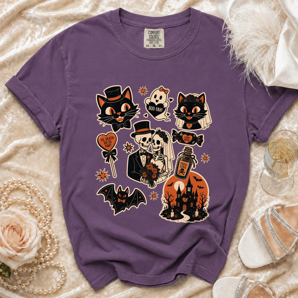 Purple t-shirt with Halloween icons: cats, ghost, skeletons, bat, haunted house, and candy.