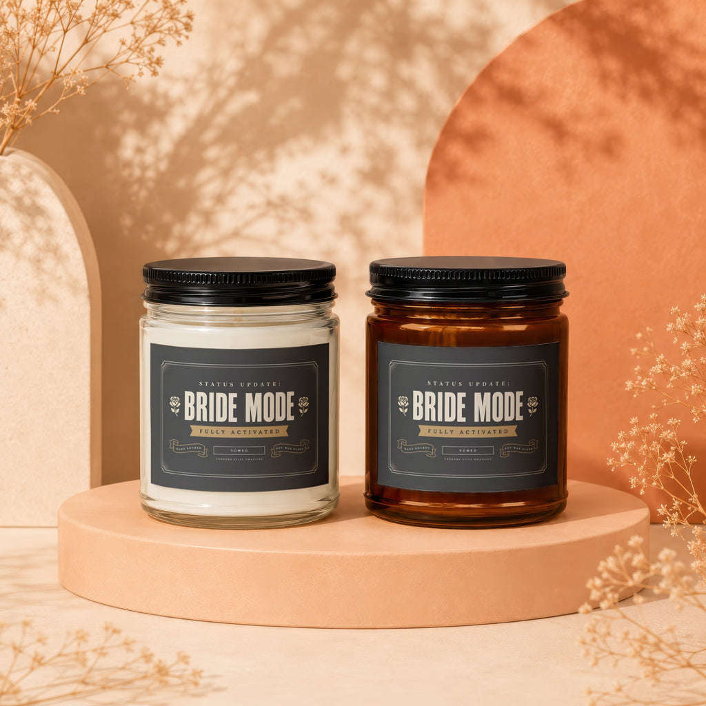 Two "Bride Mode" candles, one clear jar, one amber jar, on display.