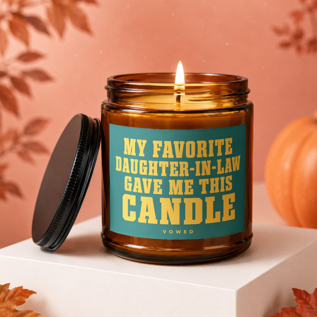 Amber glass candle with lid off, featuring text: "My Favorite Daughter-in-Law Gave Me This Candle."