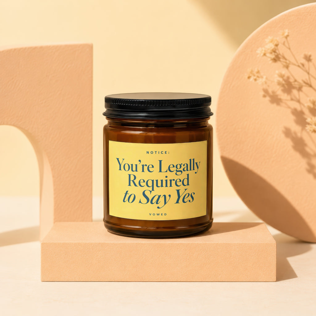 Amber jar candle with "You're Legally Required to Say Yes" text on yellow label.