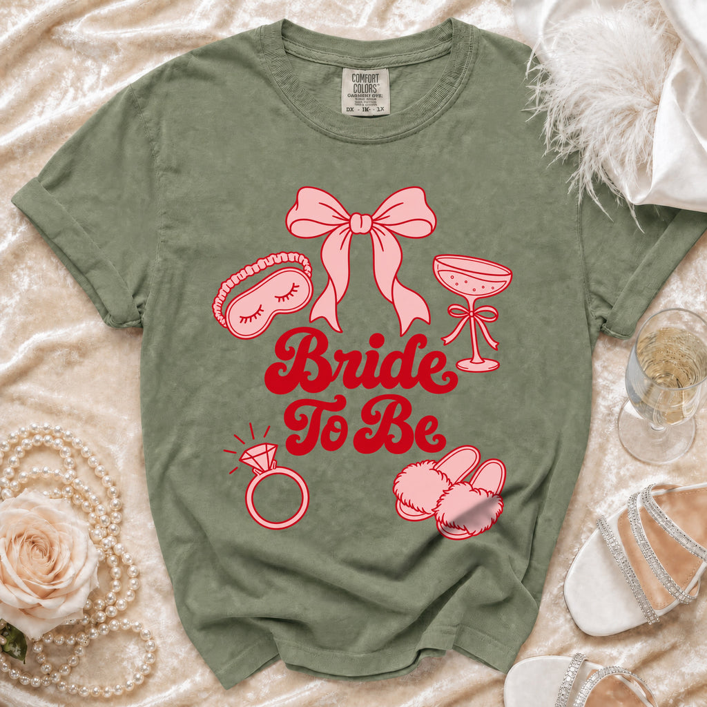 Olive green t-shirt with pink "Bride To Be" text and wedding icons.