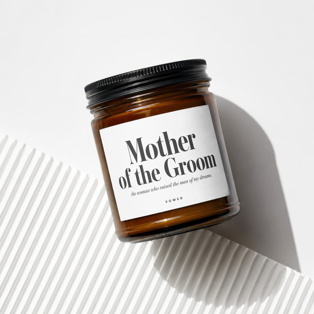 Amber candle with black lid reads "Mother of the Groom, the woman who raised the man of my dreams."
