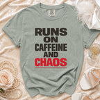 Green t-shirt with "Runs On Caffeine And Chaos" text in dark gray and red.