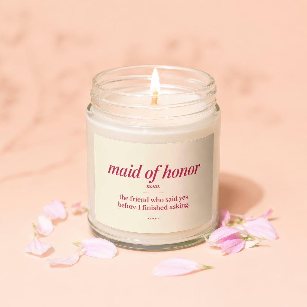 Candle with "Maid of Honor" definition and pink flower petals.