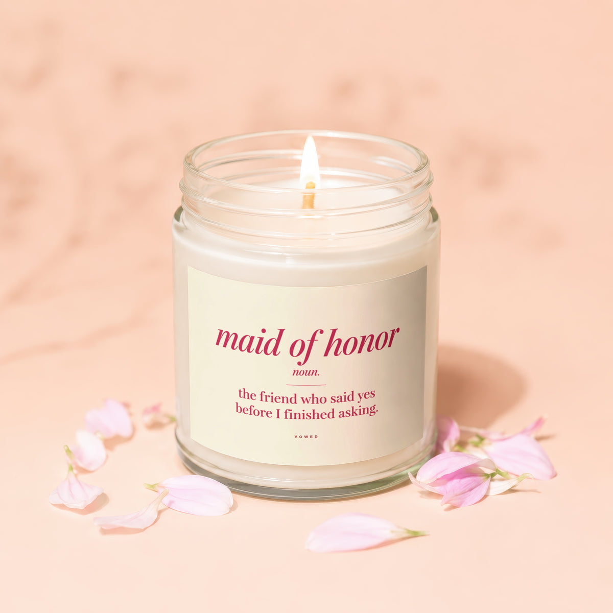 Candle with "Maid of Honor" definition and pink flower petals.