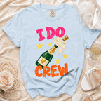 Light blue t-shirt with "I DO CREW" text and champagne bottle graphic.