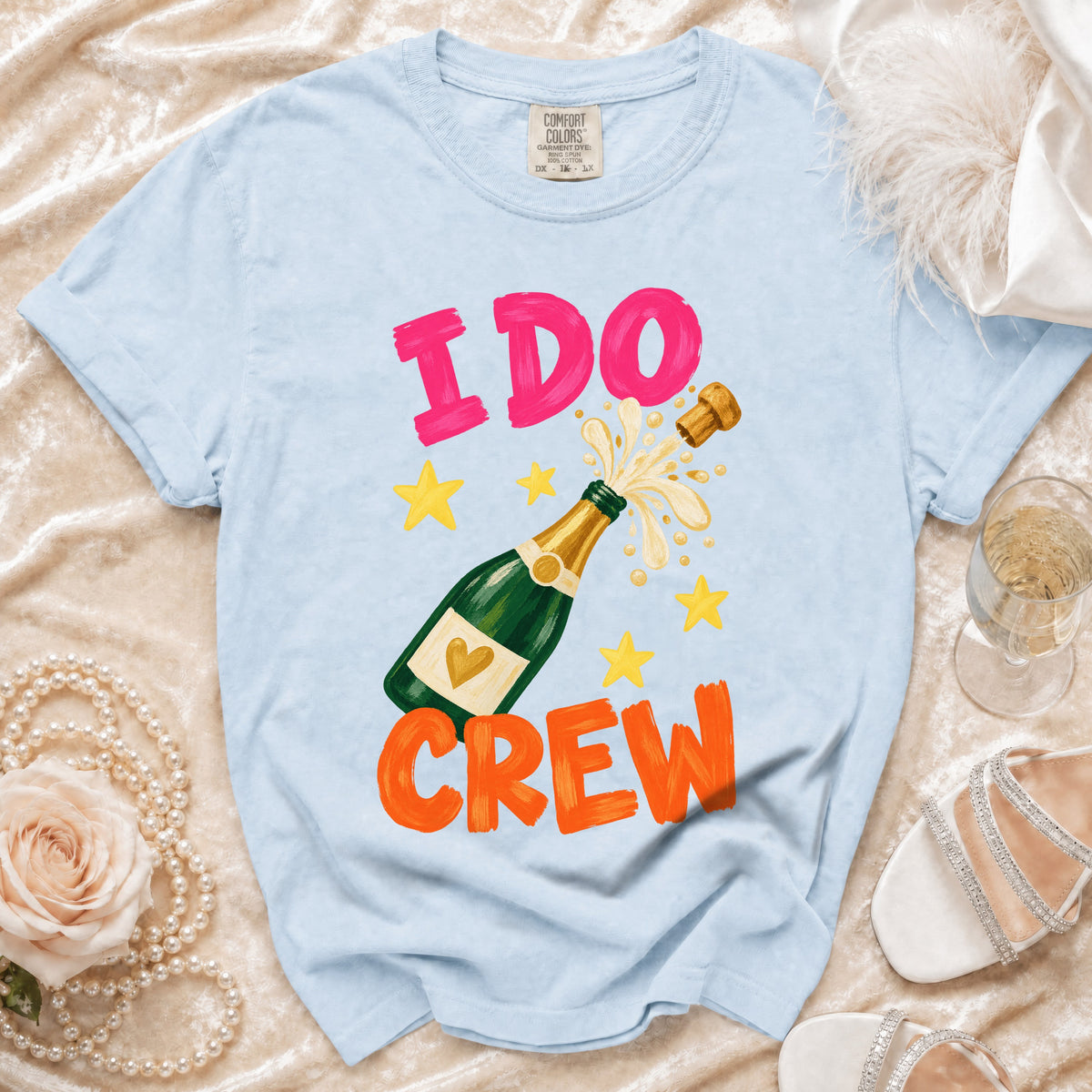 Light blue t-shirt with "I DO CREW" text and champagne bottle graphic.