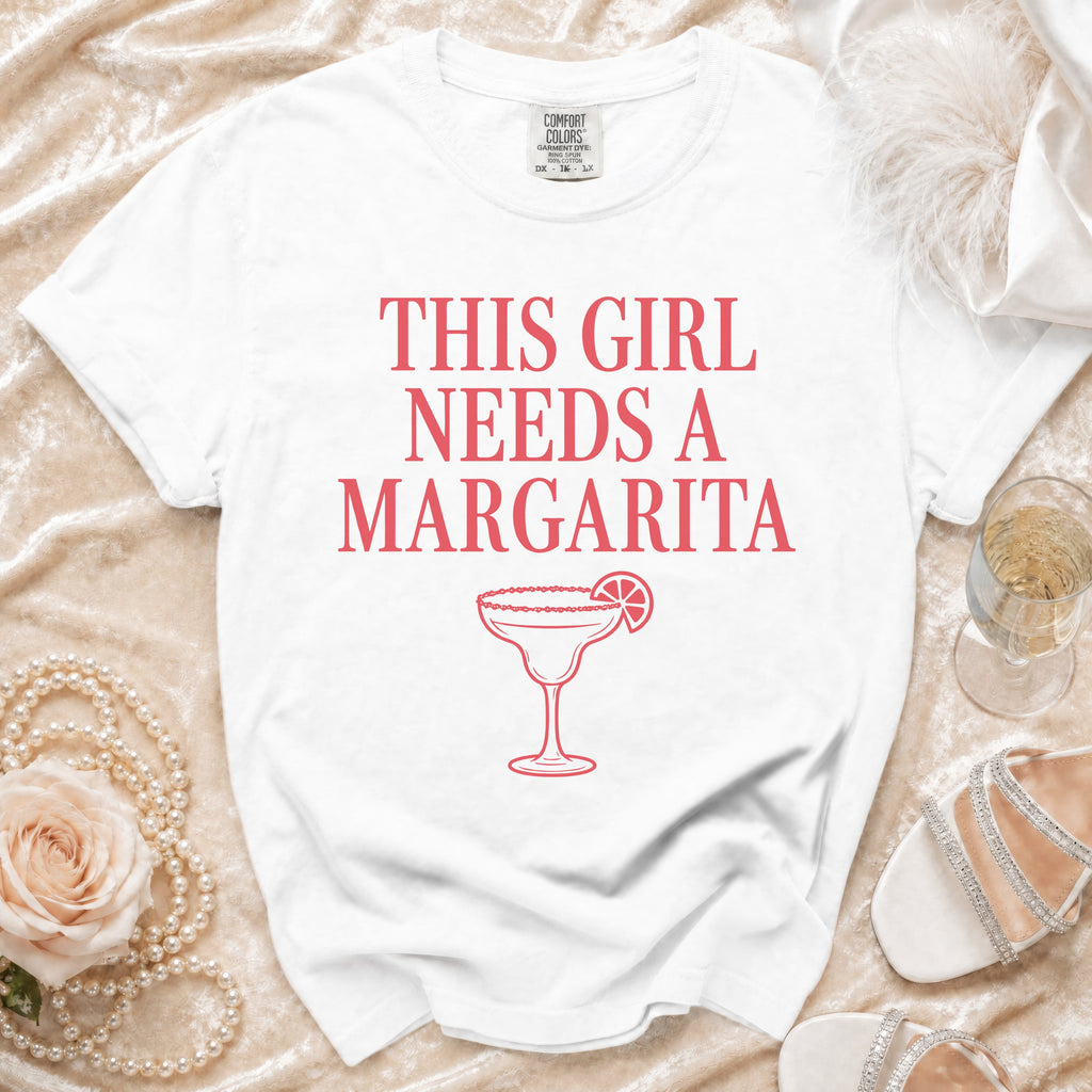 White t-shirt with "This girl needs a Margarita" text and margarita graphic.
