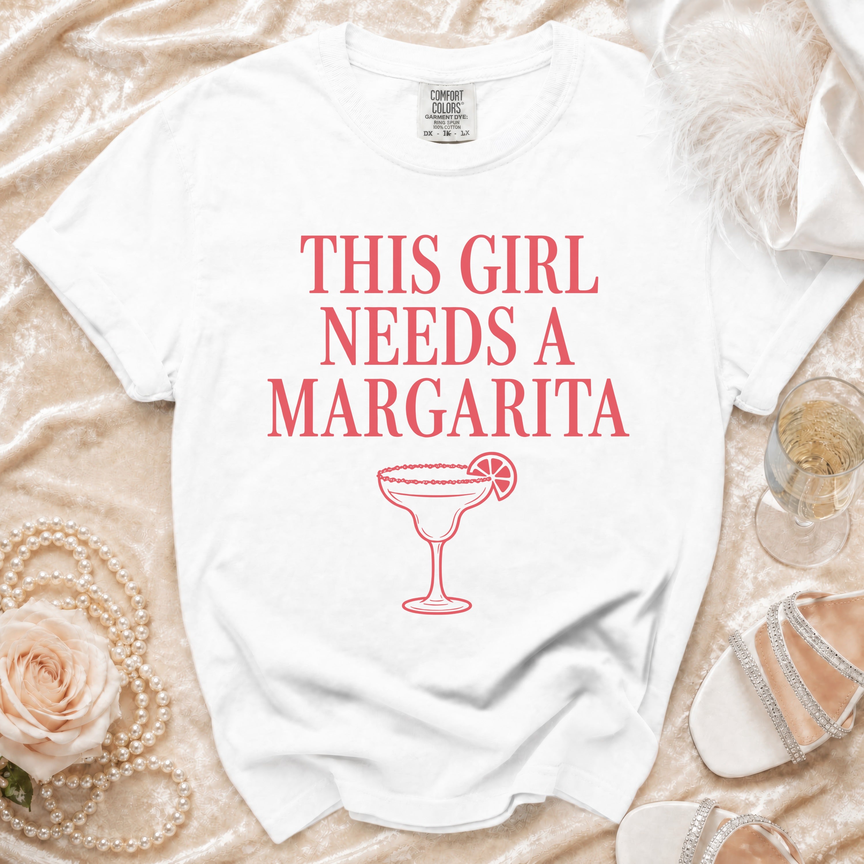 White t-shirt with "This girl needs a Margarita" text and margarita graphic.