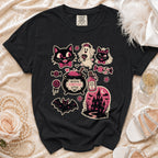 Black t-shirt with Halloween-themed graphic featuring cats, ghost, cauldron, and haunted house.