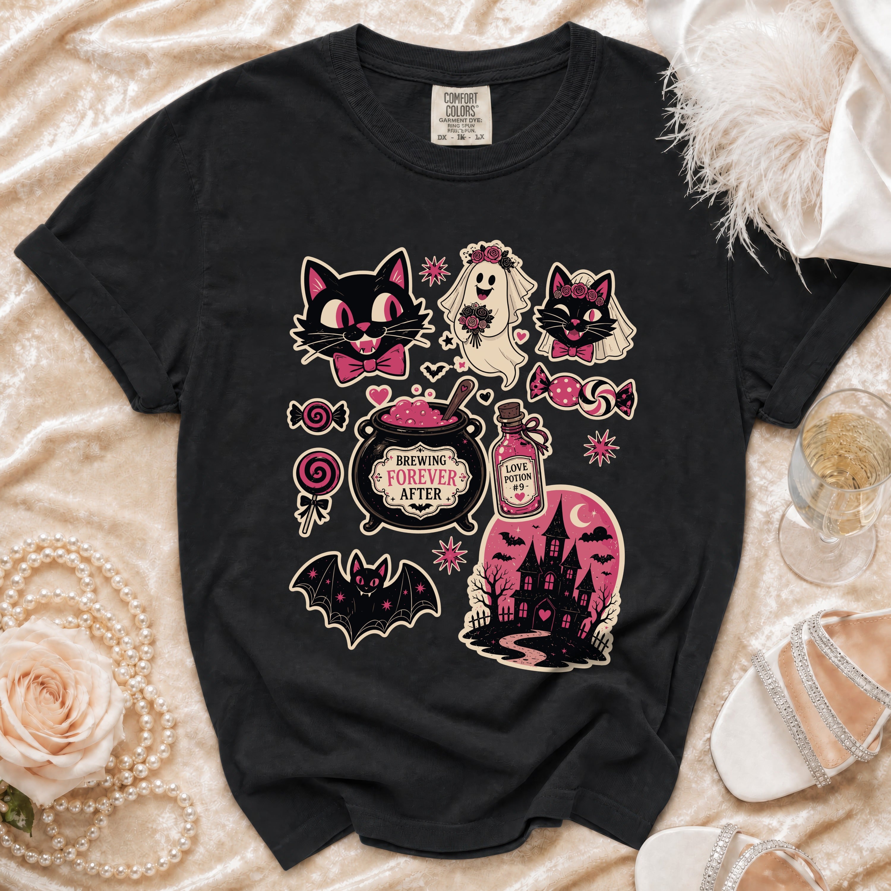 Black t-shirt with Halloween-themed graphic featuring cats, ghost, cauldron, and haunted house.