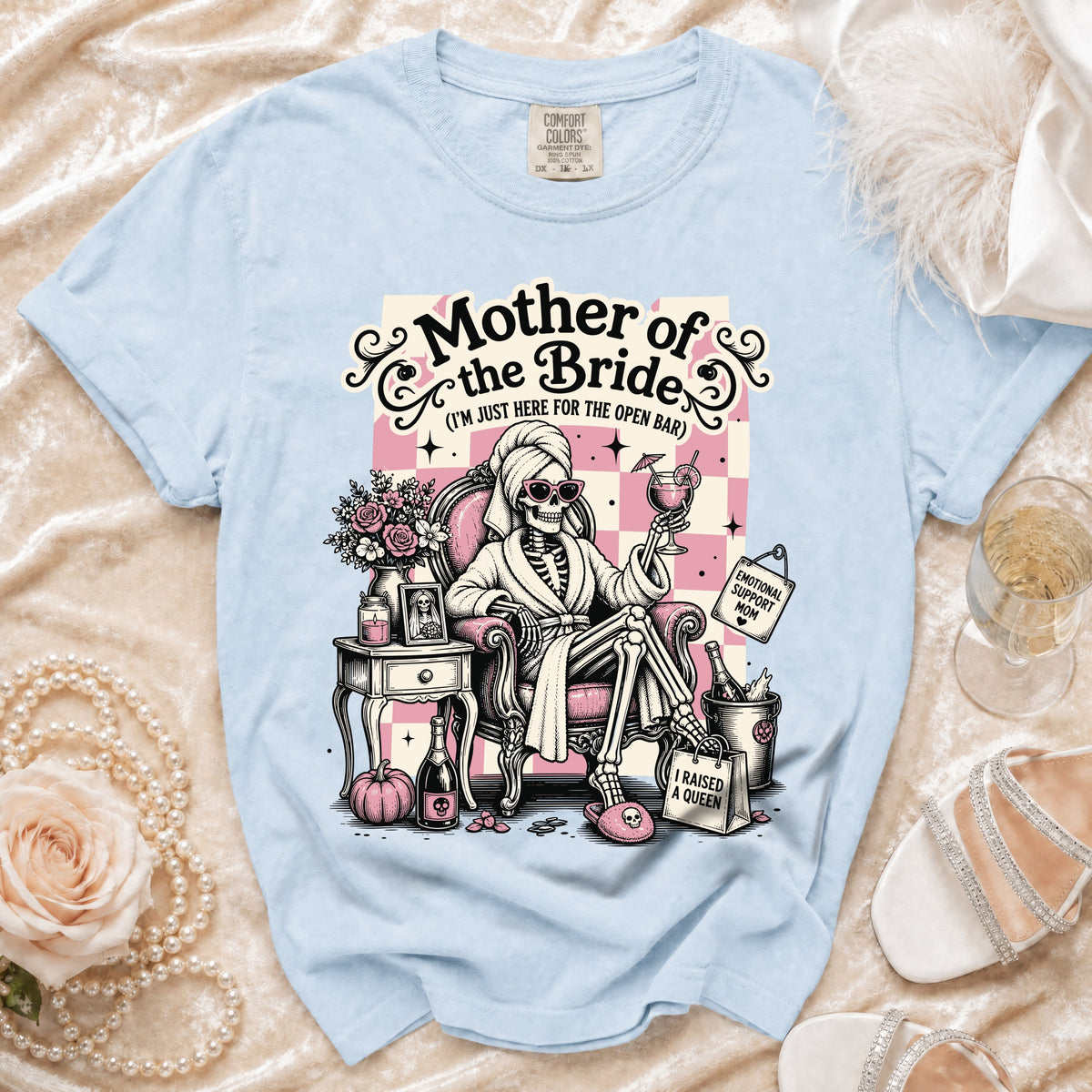 Light blue t-shirt graphic of a skeleton bride mother relaxing with drinks and text.