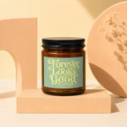 Brown glass candle with a green label that reads "Forever Looks Good."