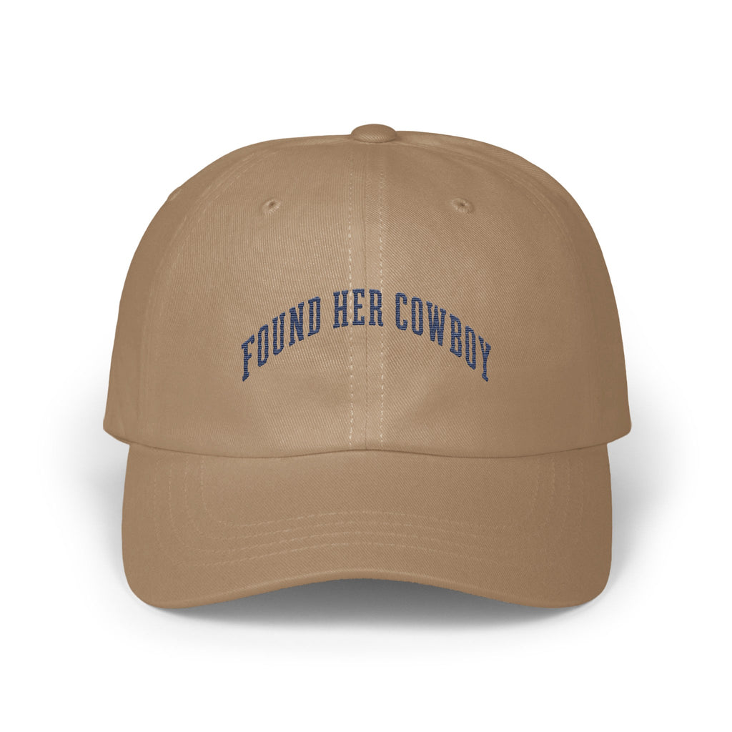 A tan baseball cap with the blue embroidered text FOUND HER COWBOY arched across the front.