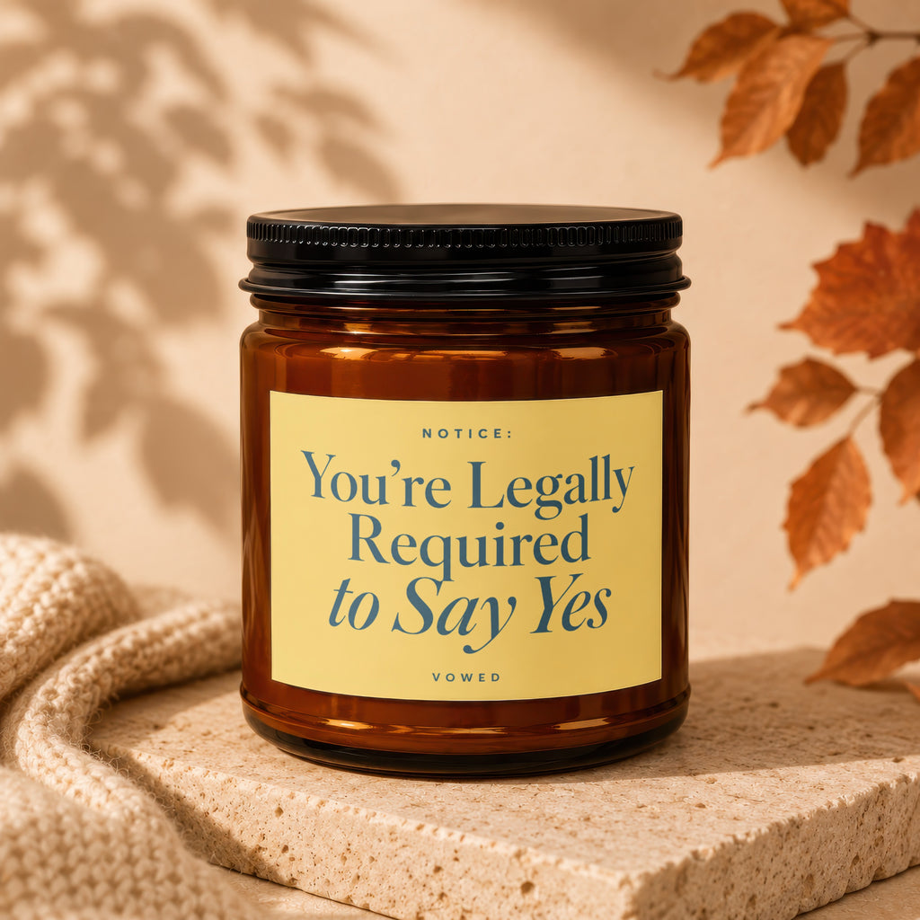 Amber candle with black lid labeled "You're Legally Required to Say Yes".