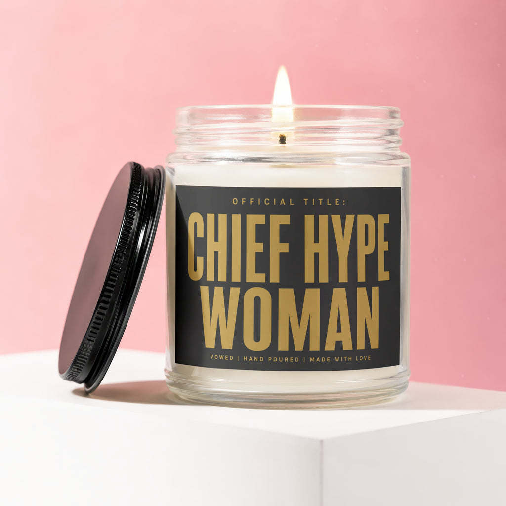 Jar candle with lit wick and "CHIEF HYPE WOMAN" gold text on a black label.