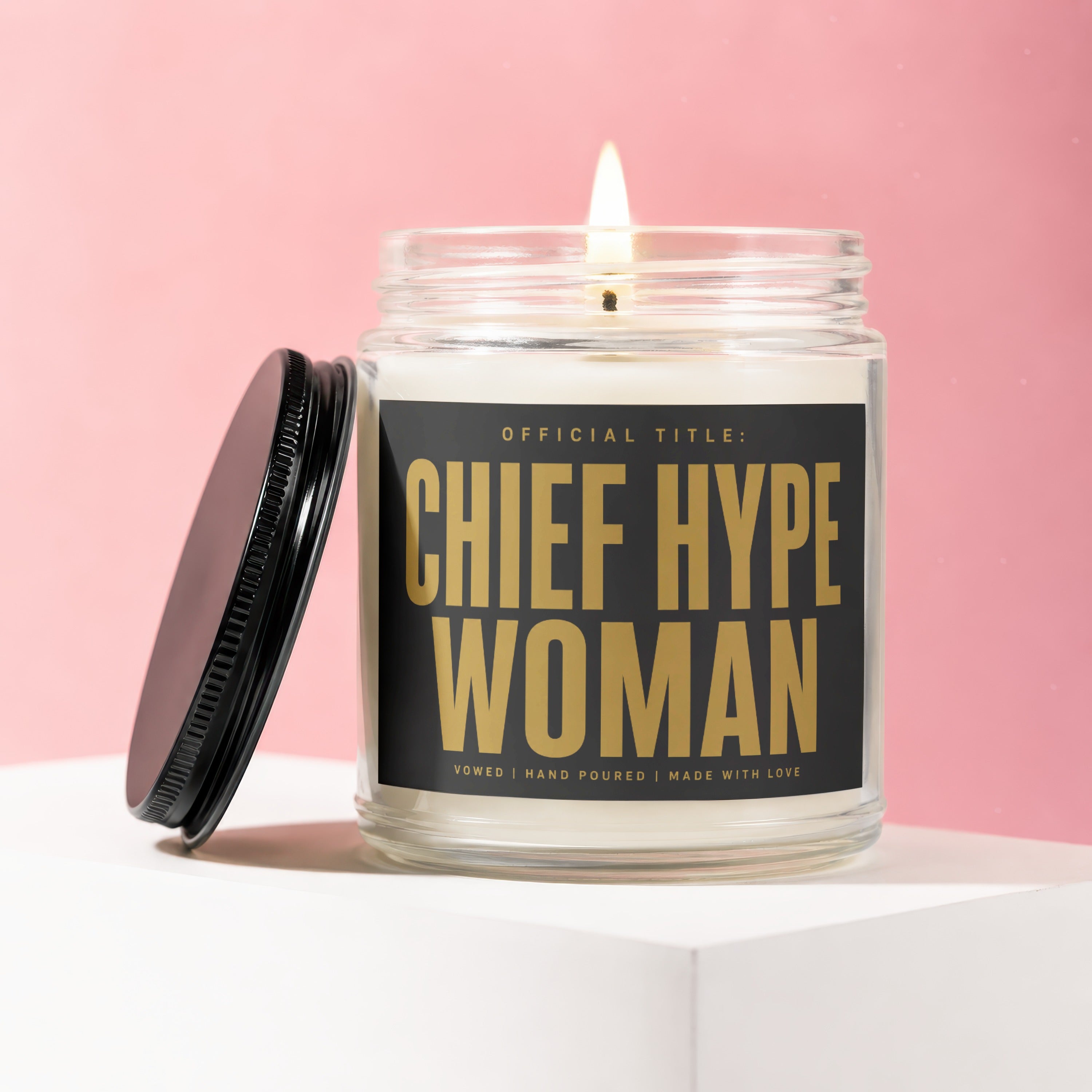 Jar candle with lit wick and "CHIEF HYPE WOMAN" gold text on a black label.