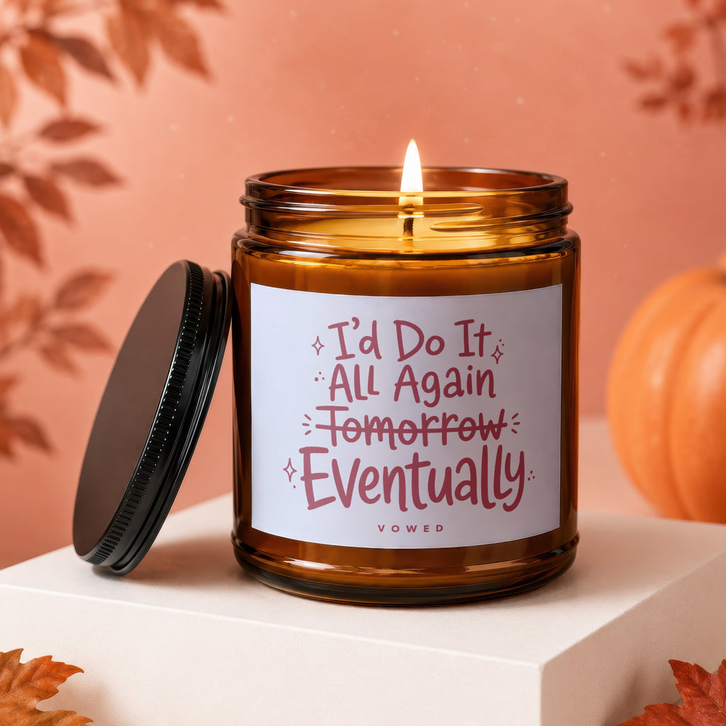 Amber jar candle with lit wick, lid off, reads "I'd do it all again tomorrow... eventually VOWED".