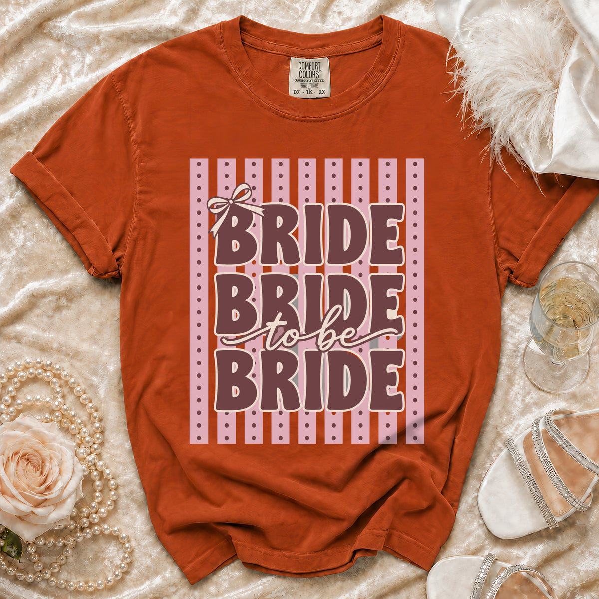 Orange t-shirt with "Bride to be Bride" text and a bow graphic.