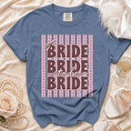 Blue t-shirt with "BRIDE BRIDE to be BRIDE" text on a striped background.