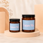 Two amber glass candles with "Future Mrs." text on blue labels.
