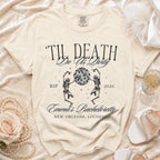 Cream t-shirt with "Til Death Do Us Party" text, skeletons, and party details.