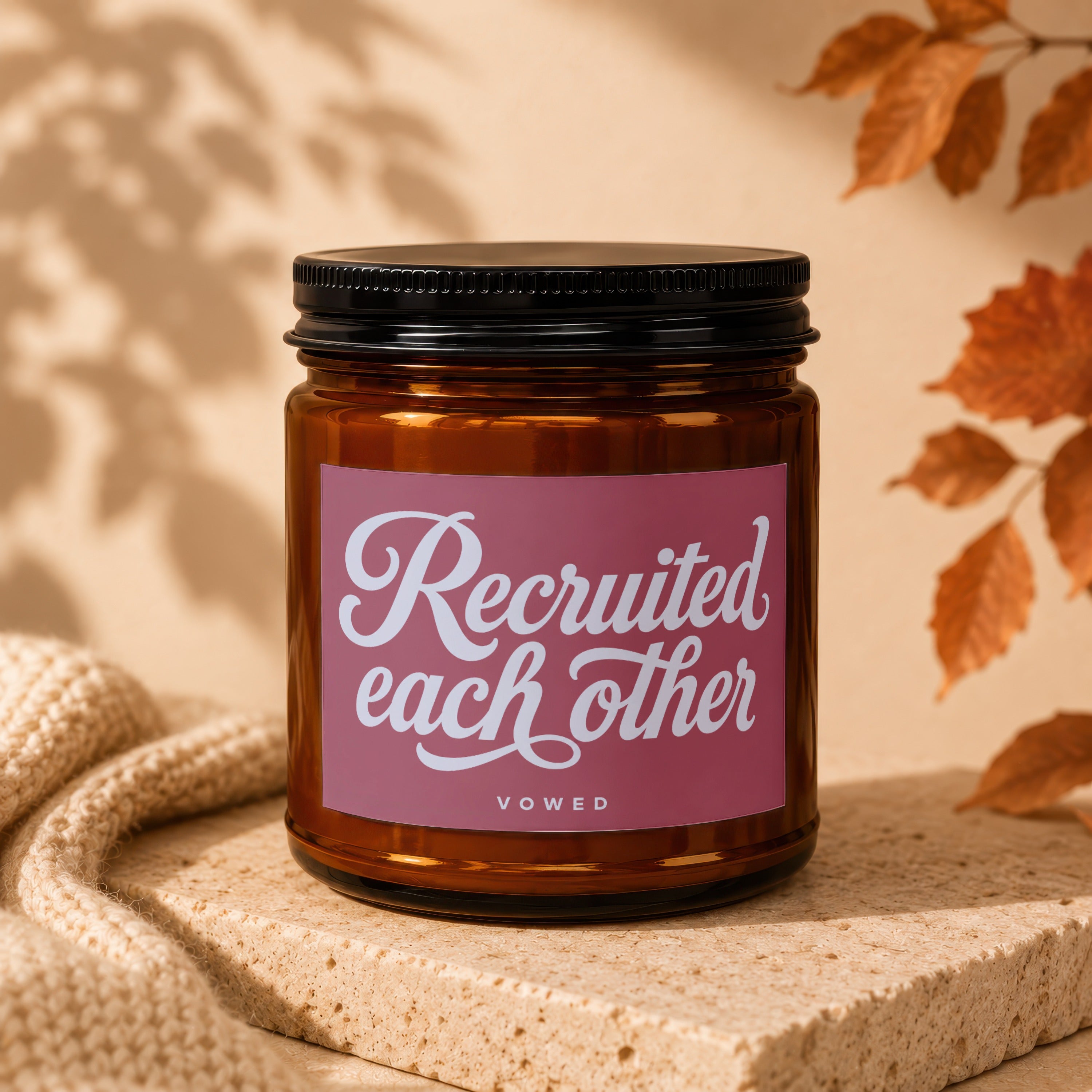 Amber candle with black lid, label reads "Recruited each other VOWED".
