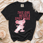 Black t-shirt with pink graphic of hand holding spicy margarita, "THIS GIRL NEEDS A SPICY MARG".