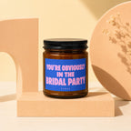 Brown candle with blue label reading "YOU'RE OBVIOUSLY IN THE BRIDAL PARTY"