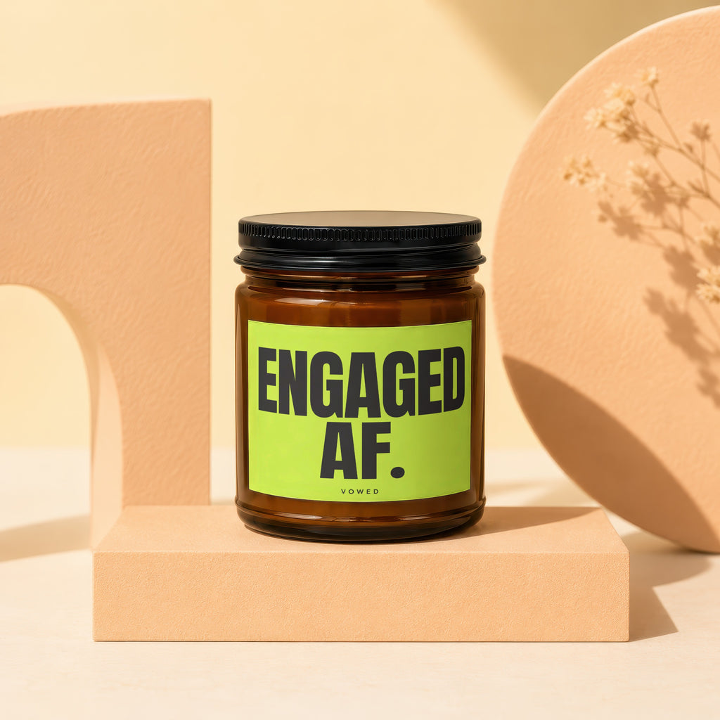 Amber jar candle with "ENGAGED AF. VOWED" text on a bright green label.