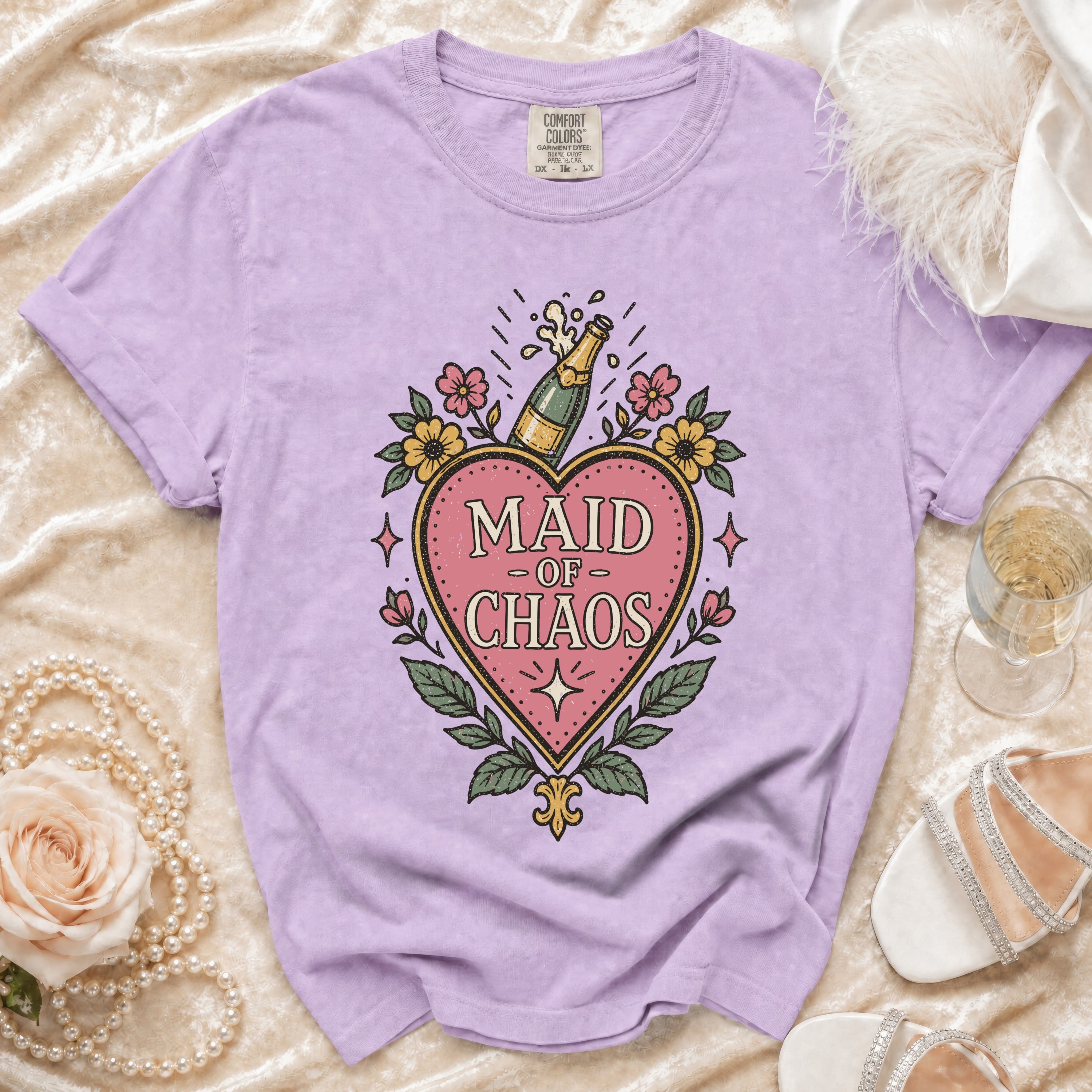 Light purple t-shirt with "Maid of Chaos" text and champagne bottle graphic.
