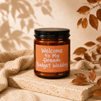 Amber candle with label reading "Welcome to My Dream Budget Wedding VOWED."