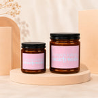 Two amber glass candles with pink labels reading "Congratulations nearlyweds" VOWED.