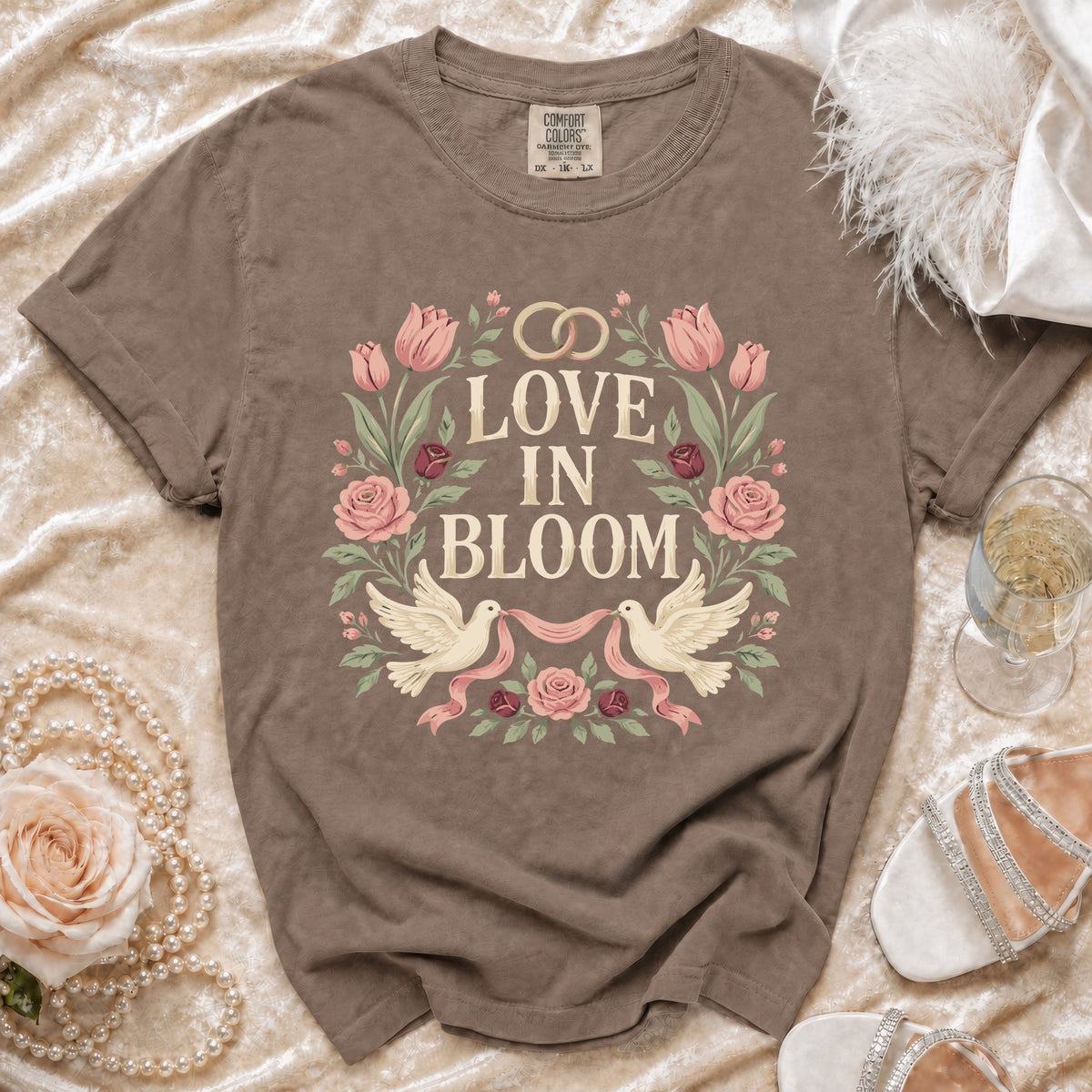 Brown t-shirt with "Love in Bloom" floral design and wedding rings.
