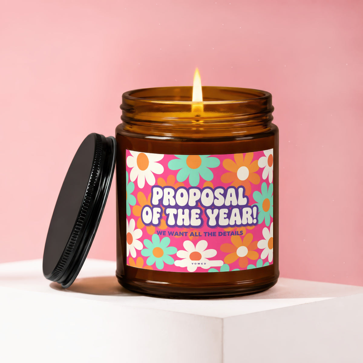 Amber jar candle with floral label reading "Proposal of the Year!" and "Vowed".