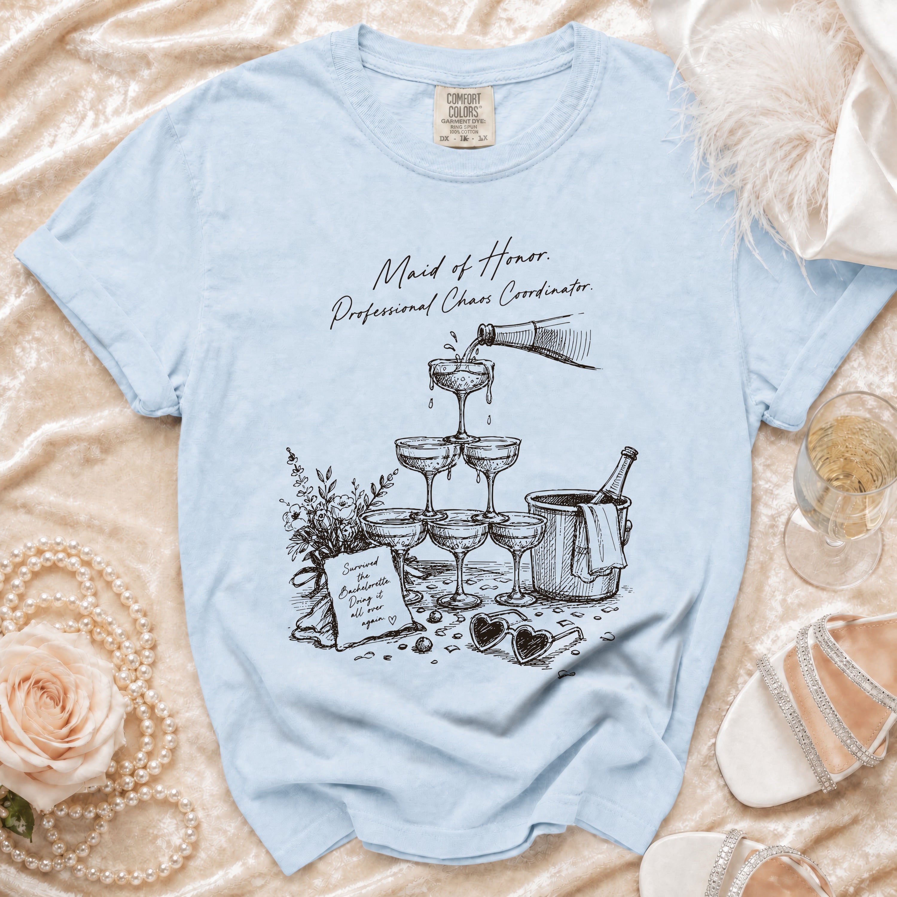 Light blue t-shirt with "Maid of Honor. Professional Chaos Coordinator." text and sketch.