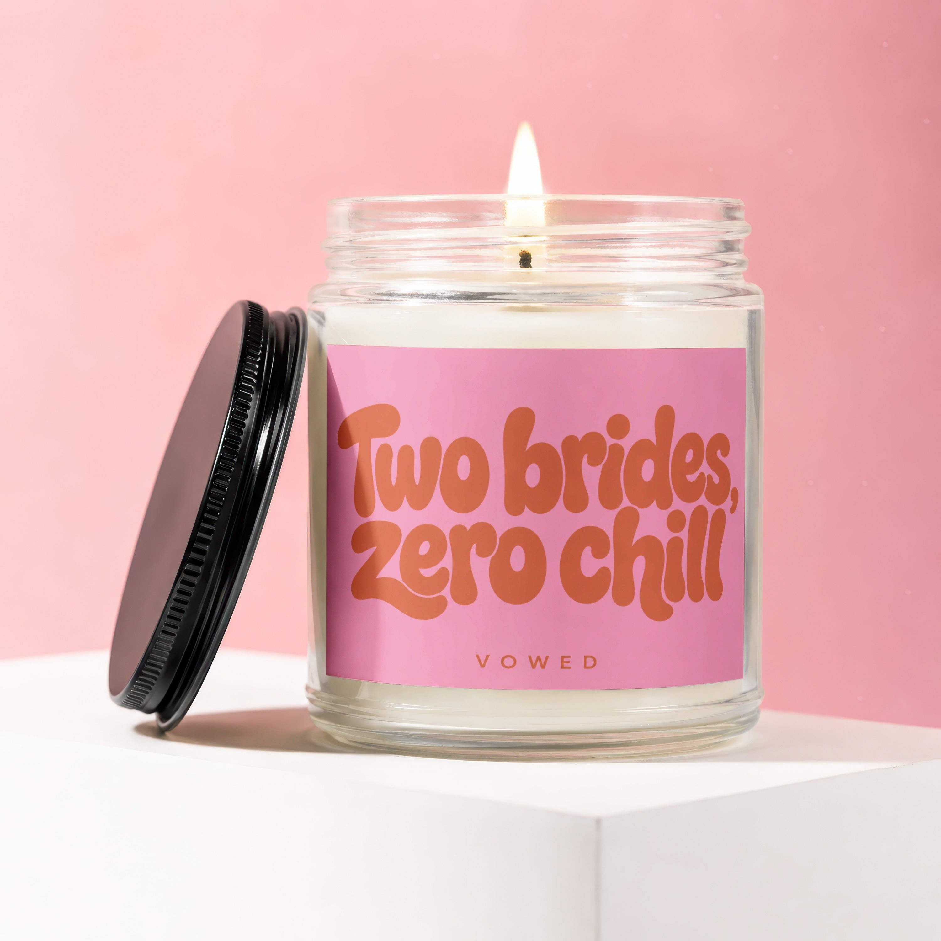 Jar candle with lit wick and black lid, featuring "Two brides, zero chill" text.