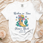 White t-shirt with "Reckless in Texas" and "Olivia's Bach" with Western graphics.